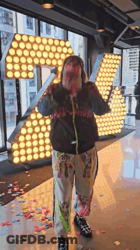 Woman Holding Confetti Cannon By Large Letter R GIF