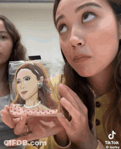 Woman Holding Cookie With Woman Drawing GIF