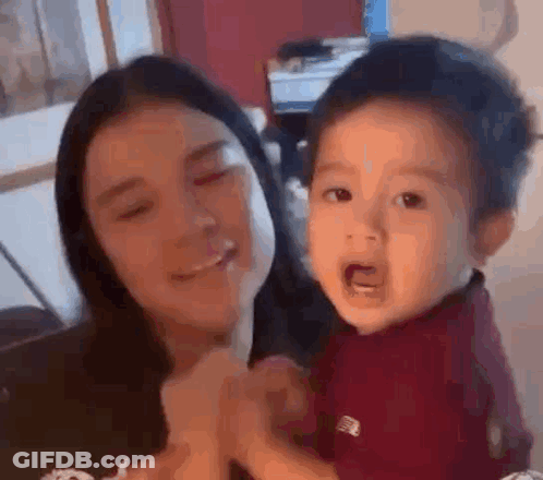 Woman Holding Crying Baby Smiling GIF