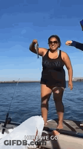 Woman Holding Fish On Dock GIF