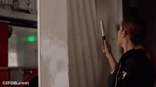 Woman Holding Flashlight In Front Of Wall GIF