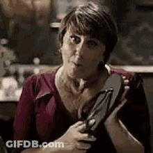 Woman Holding Flip Flops Making Funny Face GIF