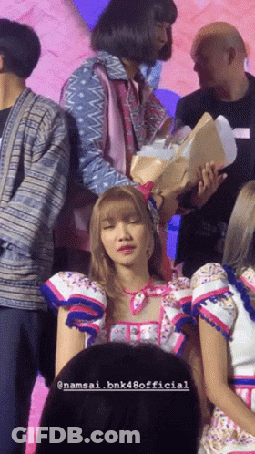 Woman Holding Flowers Surrounded By People Namsai Bnk48 Official GIF