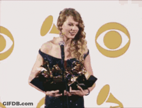 Woman Holding Grammy Award At Microphone GIF