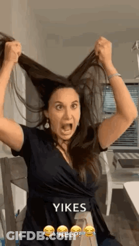 Woman Holding Hair In Air With Mouth Open GIF