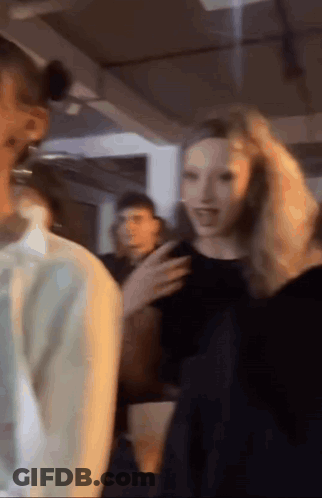 Woman Holding Hair In Group GIF