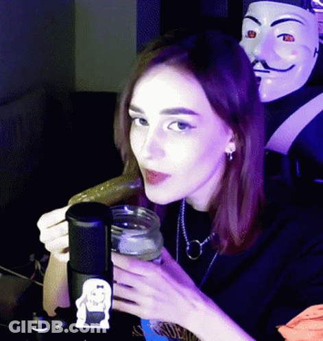 Woman Holding Jar And Cucumber At Microphone GIF