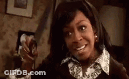 Woman Holding Knife And Smiling In Room GIF