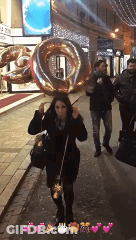Woman Holding Large Number 10 Balloon Over Head GIF