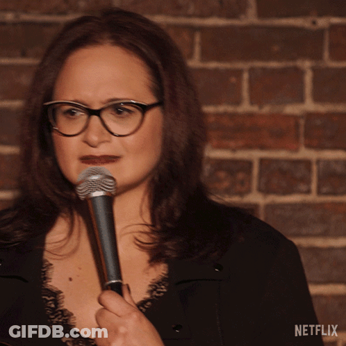 Woman Holding Microphone At Netflix Brick Wall GIF