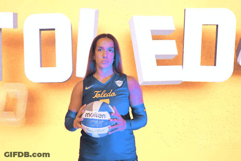 Woman Holding Molten Volleyball In Front Of Toledo Sign GIF