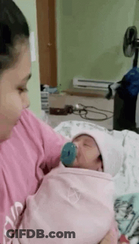 Woman Holding Newborn Baby With Pacifier GIF