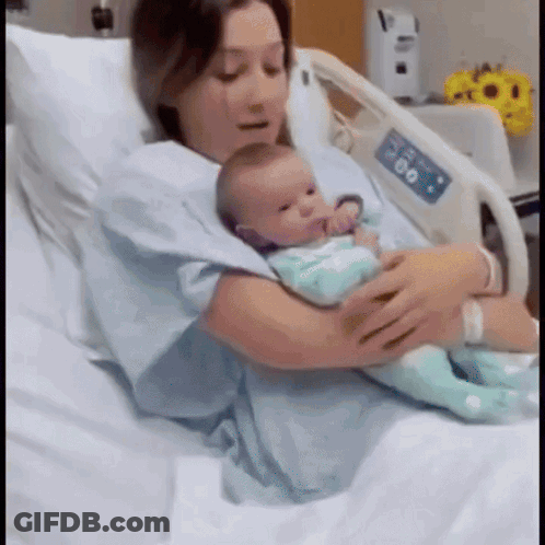 Woman Holding Newborn In Hospital Bed GIF