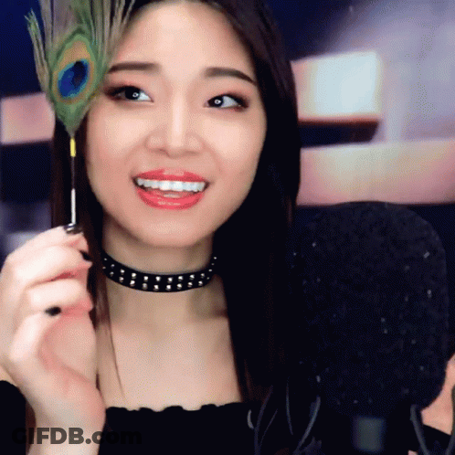 Woman Holding Peacock Feather GIF