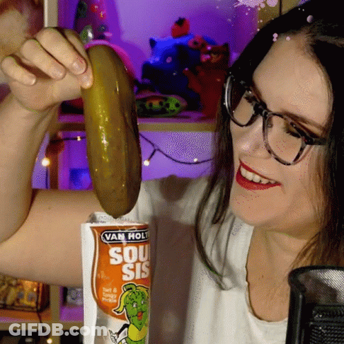 Woman Holding Pickle In Front Of Van Hol Bag GIF