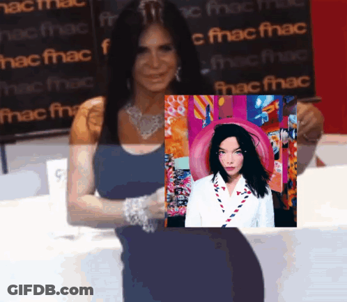 Woman Holding Picture In Front Of Fnac Sign GIF