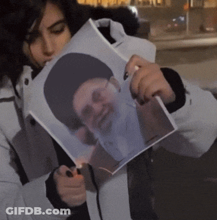 Woman Holding Picture Of Bearded Man In Hat GIF