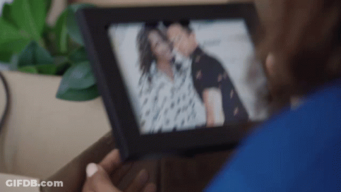 Woman Holding Picture Of Man And Woman GIF
