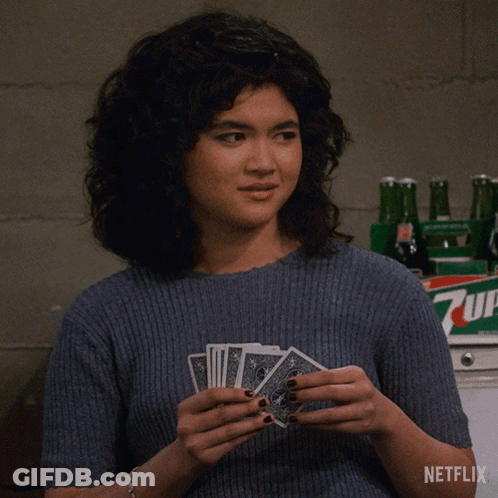 Woman Holding Playing Cards In Front Of 7Up Bottle GIF