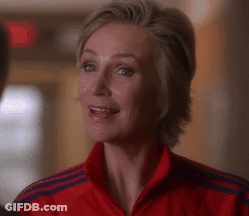 Woman Holding Red Fire Extinguisher In Front Of Trophies GIF