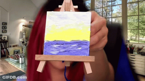 Woman Holding Small Ocean Painting On Easel GIF