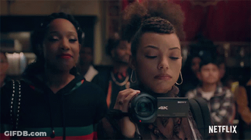 Woman Holding Sony 4K Camera In Front Of Crowd GIF