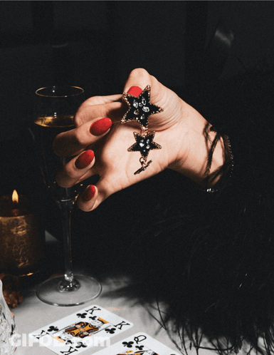 Woman Holding Star Earrings And Wine Get Our Black Friday Deal GIF