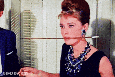 Woman Holding Sword In Mouth With Necklace And Earrings GIF