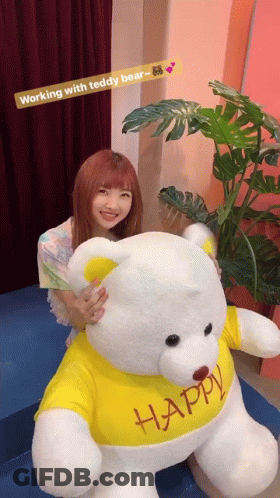 Woman Holding Teddy Bear In Yellow Shirt Saying Happy GIF
