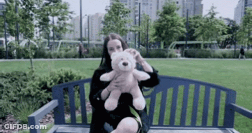 Woman Holding Teddy Bear On Park Bench GIF