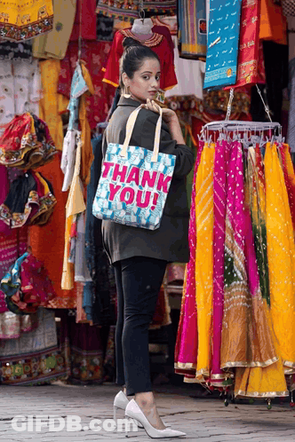 Woman Holding Thank You Bag In Front Of Store GIF
