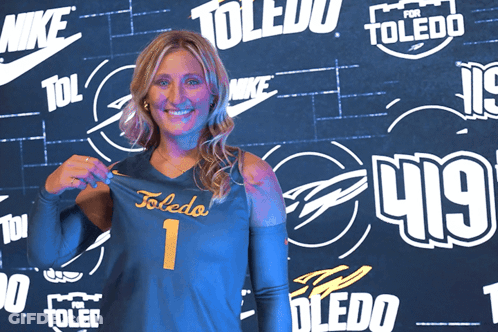 Woman Holding Toledo Jersey In Front Of Nike Wall GIF
