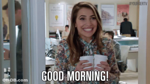 Woman Holding Two Cups Of Coffee Smiling In Office GIF