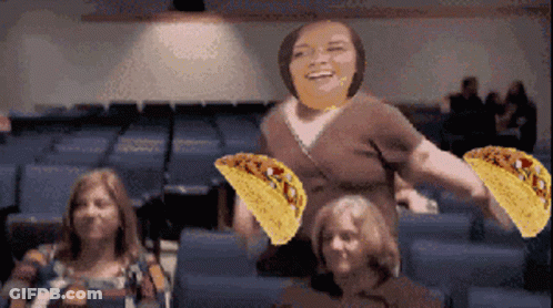 Woman Holding Two Tacos In Front Of Group GIF