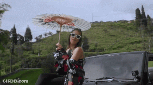 Woman Holding Umbrella Sitting On Car Back GIF