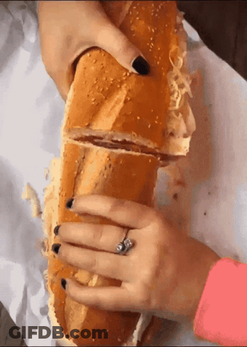 Woman Holding Very Long Sandwich With Ring GIF