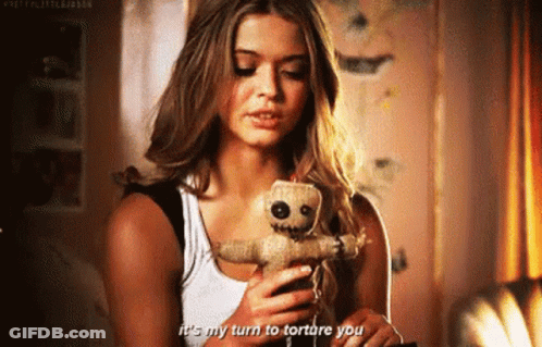 Woman Holding Voodoo Doll Talking On Phone GIF