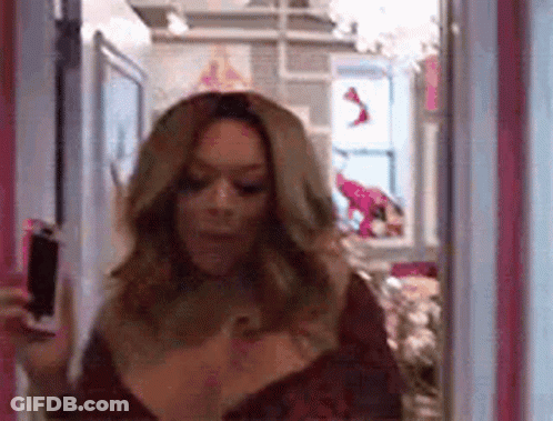 Woman Holding Wine Bottle In Front Of Mirror GIF