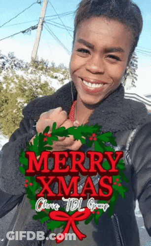 Woman Holding Wreath Saying Merry Christmas GIF