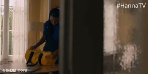 Woman Holding Yellow Duffel Bag With #Hannatv On Wall GIF