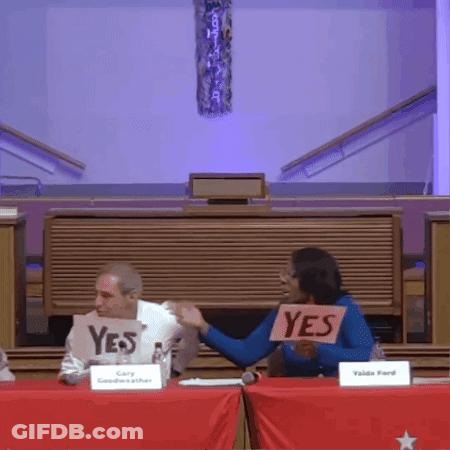 Woman Holding Yes Sign In Front Of Man GIF