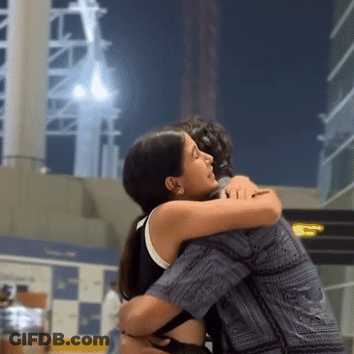 Woman Hugging Man In Front Of TC Sign GIF