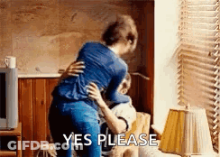 Woman Hugging Man On Couch Saying Yes Please GIF