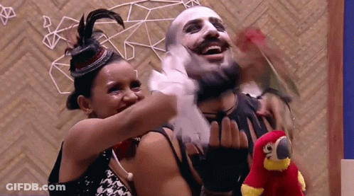 Woman Hugging Masked Man And Holding Stuffed Parrot GIF