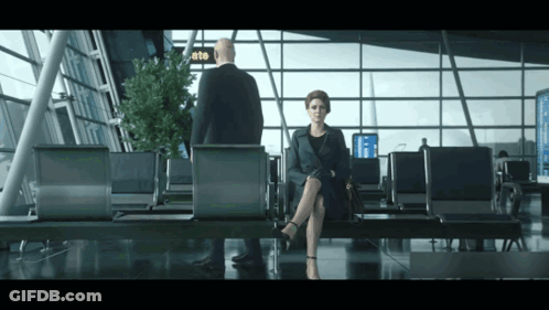 Woman In Airport Waiting Area With Man And Gate Sign GIF