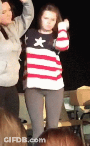 Woman In American Flag Sweater Dancing In Front Of Crowd GIF