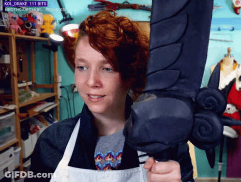 Woman In Apron Holding Sword With Kol Drake 111 Bits GIF