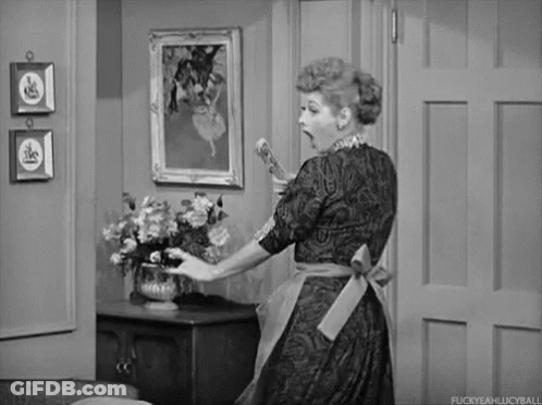 Woman In Apron Holding Vase Of Flowers GIF