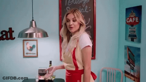 Woman In Apron In Front Of Cafe Sign GIF