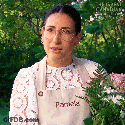 Woman In Apron Saying Pamela Holding Flowers GIF